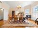 Sun-drenched dining room featuring hardwood floors, a decorative rug, and an elegant chandelier at 116 N Mulberry St, Statesville, NC 28677