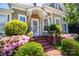 Inviting front porch with brick steps, lush azaleas, and a decorative security door at 116 N Mulberry St, Statesville, NC 28677