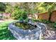 Lush backyard featuring a stone-lined pond, goldfish, and a small waterfall at 116 N Mulberry St, Statesville, NC 28677