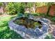 Backyard pond featuring rock surround, landscaping, and orange fish at 116 N Mulberry St, Statesville, NC 28677
