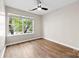 Spacious bedroom featuring hardwood floors, a ceiling fan, and natural light from a large window at 12536 Hennigan Place Ln, Charlotte, NC 28214