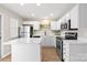 Modern white kitchen with stainless steel appliances, island, and plenty of cabinet space at 12536 Hennigan Place Ln, Charlotte, NC 28214