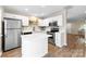 Well-lit kitchen with quartz counters, island, stainless appliances, and modern fixtures at 12536 Hennigan Place Ln, Charlotte, NC 28214