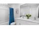 This bathroom features double sinks, white cabinets, framed mirror, and shower with blue curtain at 134 Rustling Waters Dr, Mooresville, NC 28117