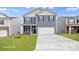 Two story home with blue siding, black shutters, and a well-manicured lawn at 134 Rustling Waters Dr, Mooresville, NC 28117
