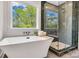 Luxurious bathroom featuring a freestanding tub, a glass-enclosed shower, and a scenic outdoor view at 1500 Nectar Way # 32, Kannapolis, NC 28083