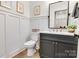 Stylish powder room featuring wainscoting, black fixtures, and a modern vanity with white countertop at 1500 Nectar Way # 32, Kannapolis, NC 28083
