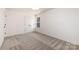 A cozy bedroom featuring neutral walls, plush carpet, and a window at 1604 Breezewood Dr, Charlotte, NC 28262