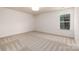 A serene bedroom with natural light, neutral walls, and plush carpet at 1604 Breezewood Dr, Charlotte, NC 28262