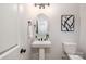 Elegant powder room features a pedestal sink, oval mirror, and modern black fixtures at 1604 Breezewood Dr, Charlotte, NC 28262