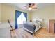 Bright bedroom featuring a ceiling fan, wood flooring, and a window with elegant blue curtains at 1605 Tate Rd # 258, Rock Hill, SC 29732