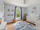 Light blue Bedroom with a white crib, blue patterned rug, and a window providing natural light and an outdoor view at 1631 Amanda Ln, Rock Hill, SC 29730