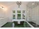 Stunning bathroom with freestanding tub, glass shower and beautiful green herringbone tile at 1804 Thomas Ave, Charlotte, NC 28205