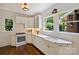 Corner view of a bright kitchen with white cabinets, hardwood floors, marble countertops, and modern appliances at 1804 Thomas Ave, Charlotte, NC 28205