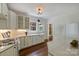 Bright white kitchen featuring farmhouse sink, gas range, hardwood floors, and marble countertops at 1804 Thomas Ave, Charlotte, NC 28205