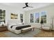 Bright main bedroom featuring natural light from large windows, ceiling fan, and a stylish sitting area at 1807 Kennesaw Dr, Charlotte, NC 28216