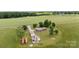 Aerial view showcasing a well-maintained home and detached garage in a rural setting with open fields and trees at 1870 Sloan Rd, Mt Ulla, NC 28125