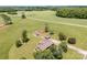 An aerial shot of a homestead nestled among green fields with multiple structures, including a residence and outbuildings at 1870 Sloan Rd, Mt Ulla, NC 28125