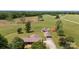 Aerial shot of a property featuring a brick home with a detached garage, additional structure, and open land at 1870 Sloan Rd, Mt Ulla, NC 28125