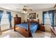 A traditionally styled bedroom offers a wood frame bed with floral bedding, decorative curtains, and coordinating side tables at 1870 Sloan Rd, Mt Ulla, NC 28125