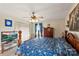 This traditionally styled bedroom has floral bedding, a ceiling fan and light fixture, with a television on a stand at 1870 Sloan Rd, Mt Ulla, NC 28125