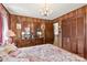 This bedroom features wood walls, a chandelier, floral bedding, a dresser and lamps to complement the traditionally styled space at 1870 Sloan Rd, Mt Ulla, NC 28125