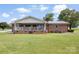 This brick home with a metal roof has a covered back porch, a chimney, and an expansive green lawn at 1870 Sloan Rd, Mt Ulla, NC 28125