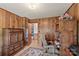 A charming office space features wood walls, a computer work station and a display cabinet with an open doorway to another room at 1870 Sloan Rd, Mt Ulla, NC 28125
