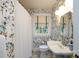 Charming bathroom with floral wallpaper, classic fixtures, and a bright window at 2033 Charlotte Dr, Charlotte, NC 28203