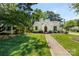 Charming white Tudor-style home with a well-manicured lawn on a sunny day at 2033 Charlotte Dr, Charlotte, NC 28203