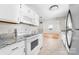 Bright kitchen with white cabinets, stone countertops, stainless steel appliances, and tile floors at 22330 Torrence Chapel Rd, Cornelius, NC 28031