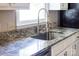 Close-up of kitchen sink with granite countertops, stainless steel faucet, and white cabinets at 22330 Torrence Chapel Rd, Cornelius, NC 28031