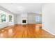 Bright living room featuring a white brick fireplace, large bay window, and gleaming hardwood floors at 22330 Torrence Chapel Rd, Cornelius, NC 28031