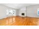 Light-filled living space featuring hardwood floors, a brick fireplace, and large windows at 22330 Torrence Chapel Rd, Cornelius, NC 28031