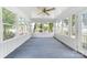 Relaxing sunroom filled with natural light featuring many windows, a ceiling fan, and blue carpet at 22330 Torrence Chapel Rd, Cornelius, NC 28031