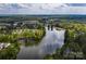 An aerial view highlights a picturesque lake surrounded by lush greenery and charming residential neighborhoods at 23147 Whimbrel Cir, Fort Mill, SC 29707