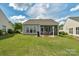 A backyard with a covered patio and a grassy yard offers an ideal space for relaxation and outdoor entertaining at 23147 Whimbrel Cir, Fort Mill, SC 29707