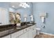 Bathroom featuring stylish granite countertops, white cabinets, and serene blue walls for a spa-like feel at 23147 Whimbrel Cir, Fort Mill, SC 29707