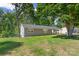 This home offers a large grassy yard and grey painted brick; it is shaded by large trees at 2322 Hedgewood Cir, Gastonia, NC 28052
