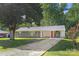 The front exterior has a gravel driveway, an orange front door, and a covered carport at 2322 Hedgewood Cir, Gastonia, NC 28052
