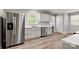 Modern kitchen with stainless steel appliances, white cabinets, marble countertops, and wood-look flooring at 2322 Hedgewood Cir, Gastonia, NC 28052