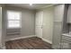 Neutral-painted kitchen, featuring a window, light laminate floors, and a white door at 2322 Hedgewood Cir, Gastonia, NC 28052