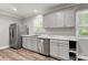 Updated kitchen featuring stainless steel appliances, white cabinets, marble countertops, and wood-look flooring at 2322 Hedgewood Cir, Gastonia, NC 28052