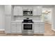 Updated kitchen with stainless steel oven, microwave, white cabinets, marble countertop, and wood-look floors at 2322 Hedgewood Cir, Gastonia, NC 28052
