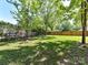 Lush green backyard featuring a spacious grassy area and mature trees at 2401 Birnen Dr, Charlotte, NC 28210