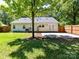 The backyard features a patio, mature trees, a fence, and the rear exterior of the home at 2401 Birnen Dr, Charlotte, NC 28210