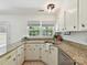 Well-lit kitchen with granite countertops, white cabinets, and updated fixtures at 2401 Birnen Dr, Charlotte, NC 28210
