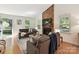 Bright living room featuring a brick fireplace, hardwood floors, and comfortable seating at 2401 Birnen Dr, Charlotte, NC 28210