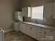 Cozy kitchen featuring white cabinets, granite-look countertops, and laundry hookups at 2433 Booker Ave, Charlotte, NC 28216