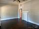 Spacious living room with hardwood floors, classic fireplace mantel, and ceiling fan at 2433 Booker Ave, Charlotte, NC 28216